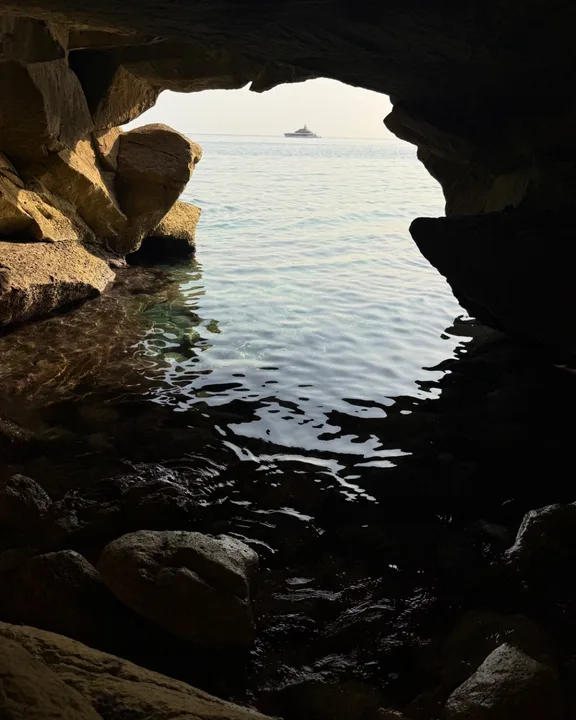 Photo of a sea cave with a ship